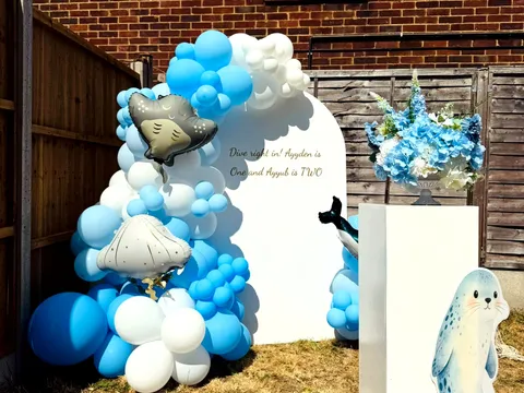 Blue and white balloon garland arch backdrop styled for an under-the-sea themed birthday