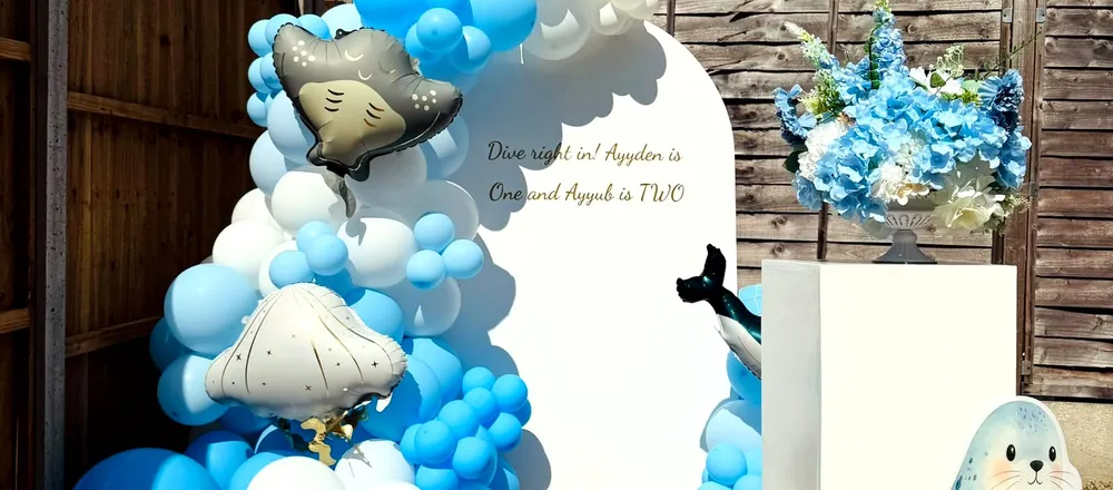 Blue and white balloon garland arch backdrop styled for an under-the-sea themed birthday